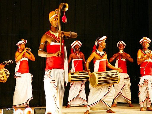 Traditional Kandyan drummers performing in white and red costume